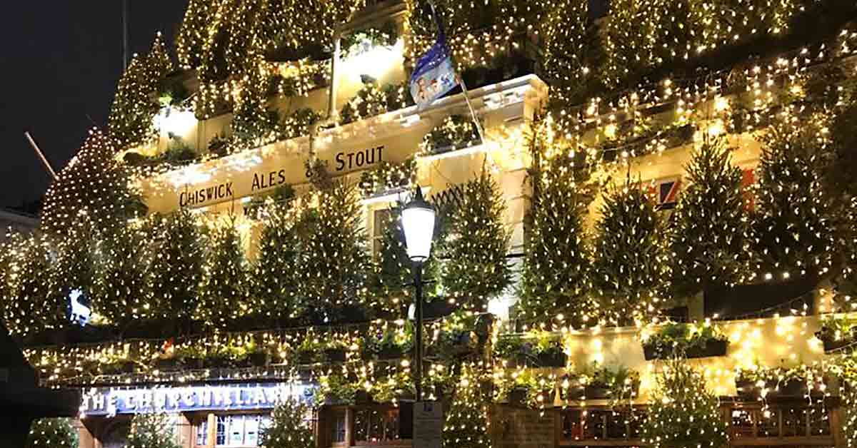 Pub exterior covered with trees and lights.