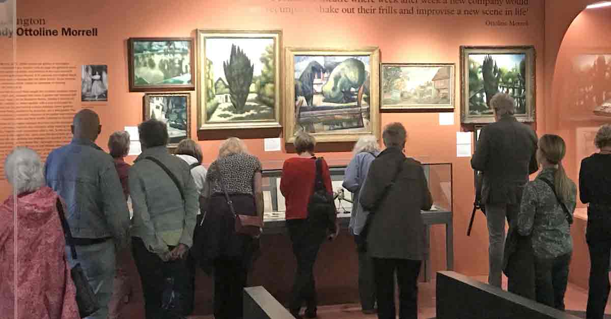 Visitors admiring impressionistic paintings.