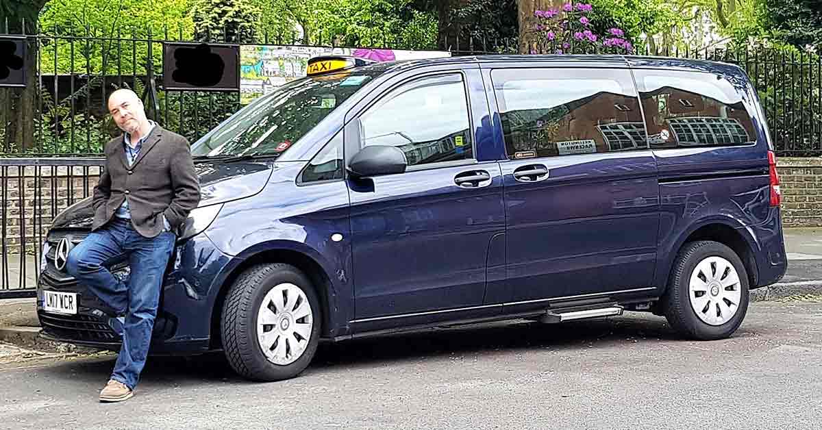 Leaning on the bonnet of his blue Vito taxi