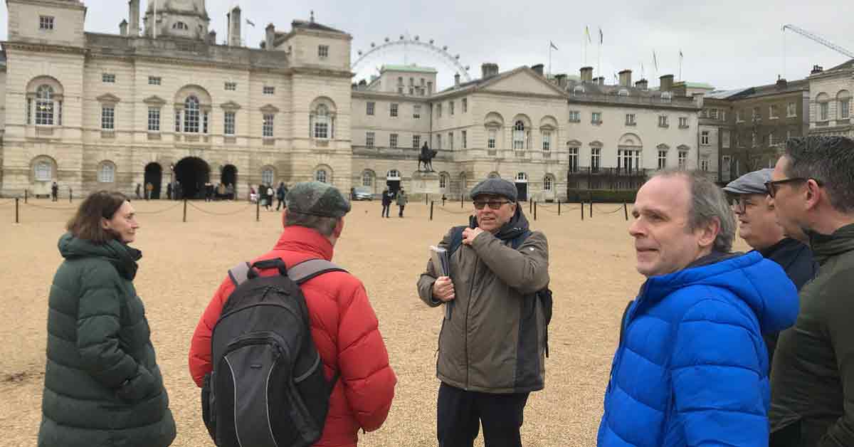 Rob and guests in front of the classic, brick-and-stone building with arched entrance