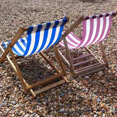 Red striped and blue striped deckchair on Brighton beach.