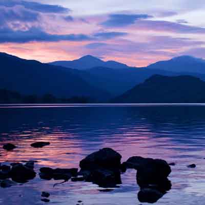 Loch Lomand with surrounding hills at sunrise.