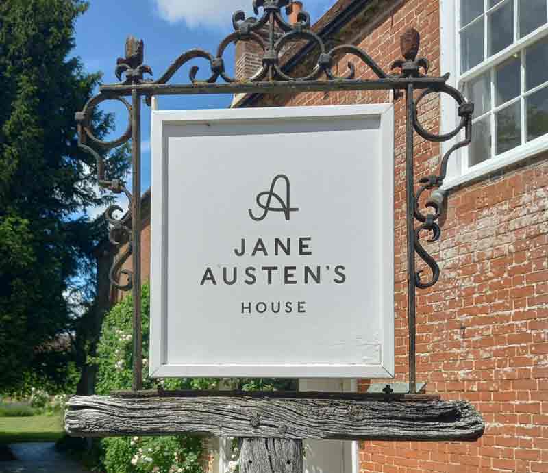 Ornate sign outside pretty red brick buidling.