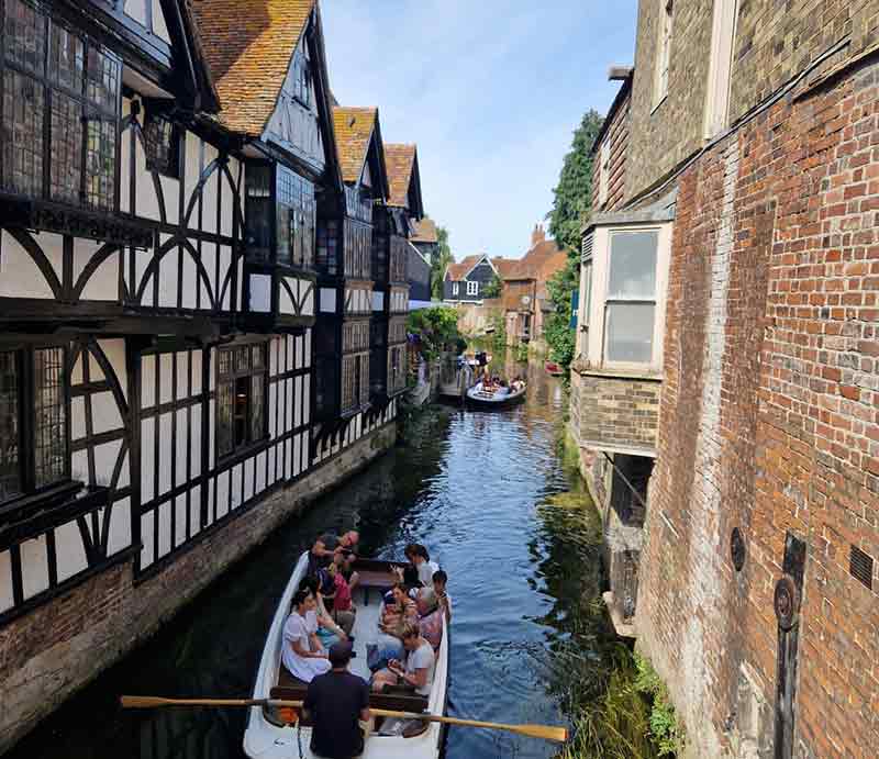 Tourist boat by 16th-centruy timber framed building.