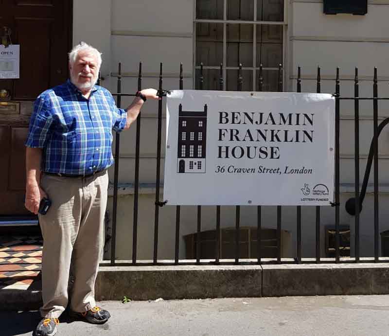 Guest outside on street next to sign.