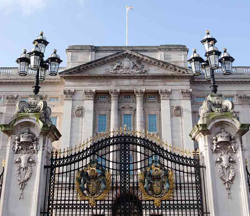 The facade through the ornate black & gold front gates.