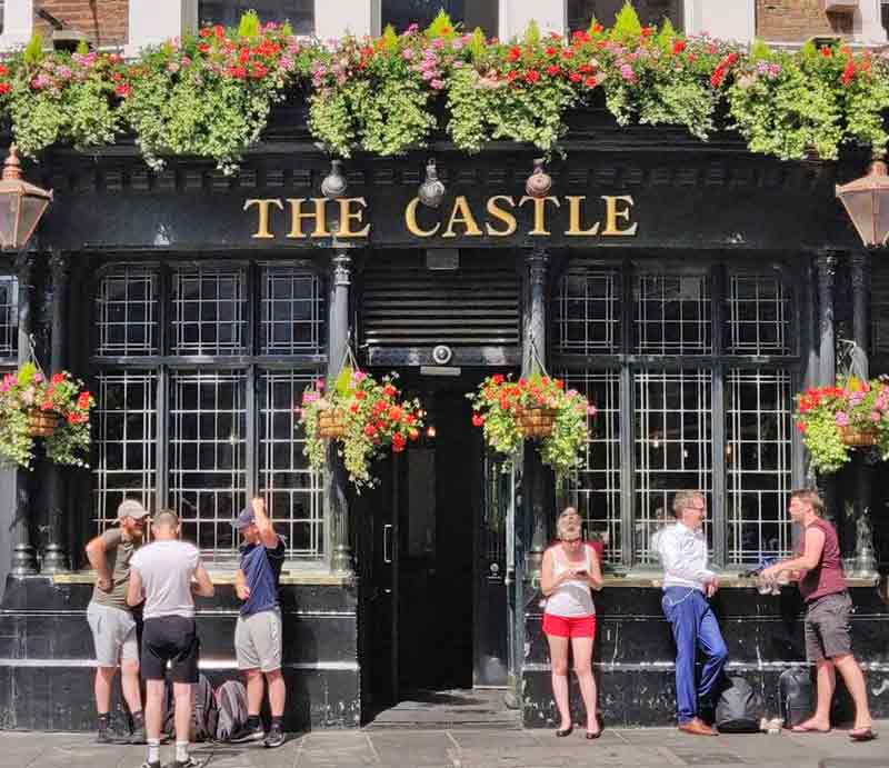 Customers outside the balck painted exterior with flower arrangements.