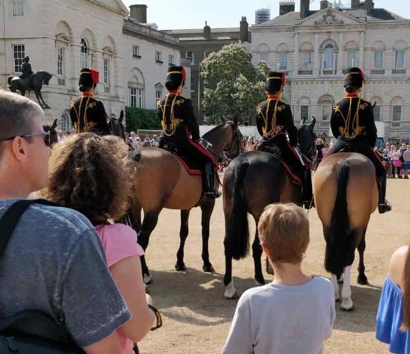 Rear view in uniform on horseback with guests.