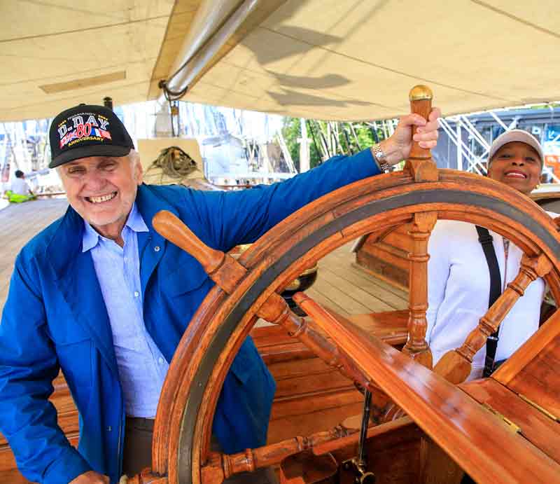 Smiling guest turning the ship's wheel.