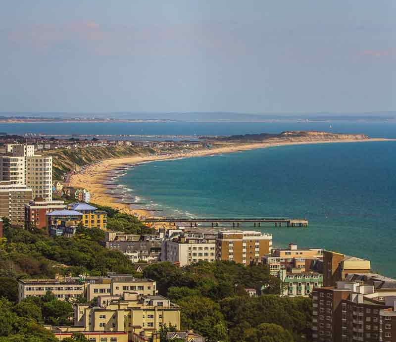 Aerial view of coastline with sea, beach and hotels.