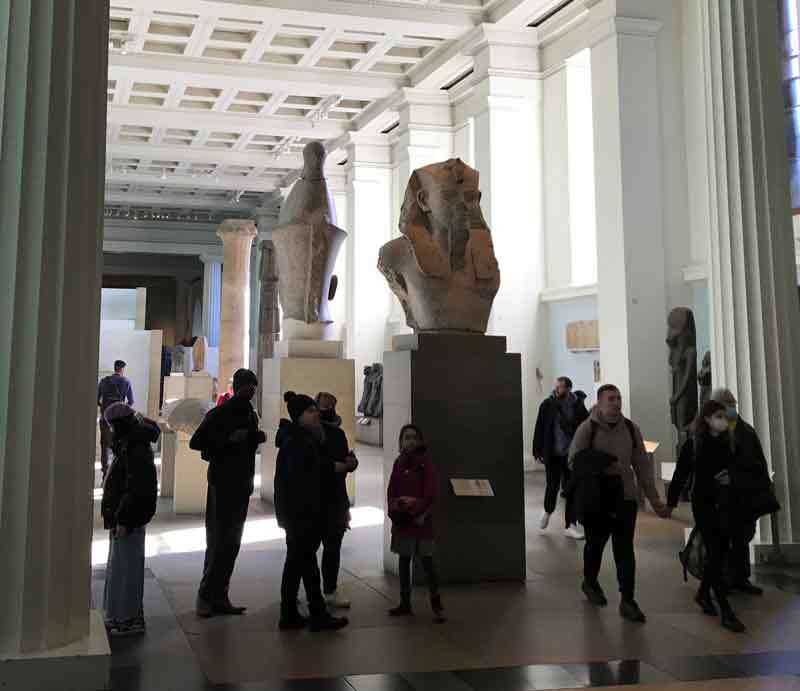 Visitors enjoying large Egyptian architectural sculptures.