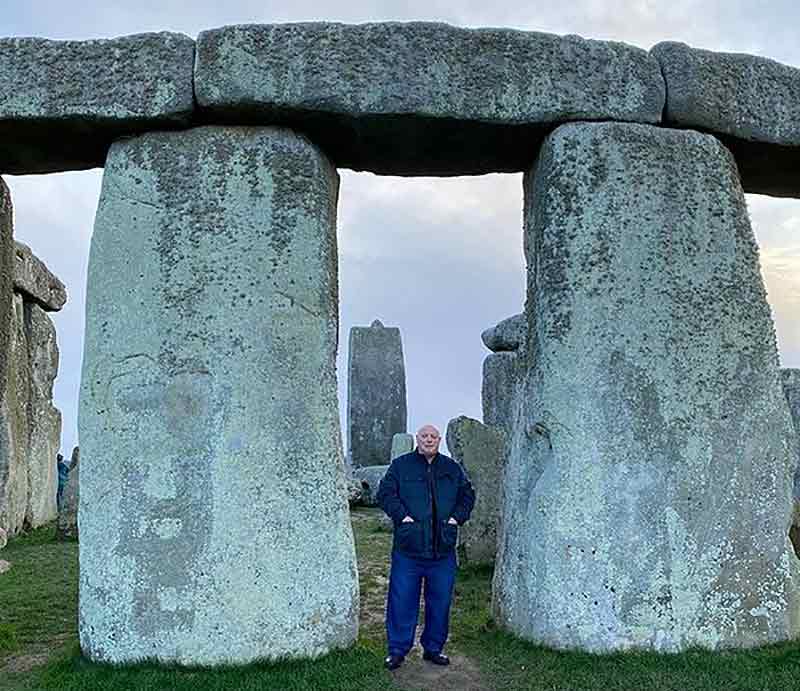 Standing between two sarsen stones at Stonehenge.