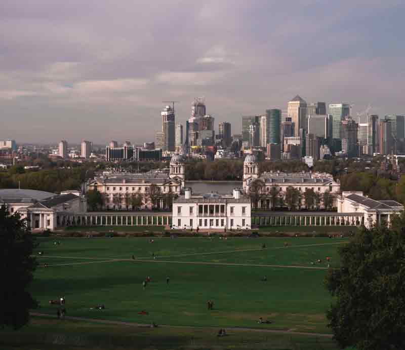 Grassland and the Queen's House with London skyscrapers in the distance.