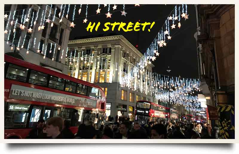 Christmas lights, London Buses and shoppers with caption 'Hi Street!'.