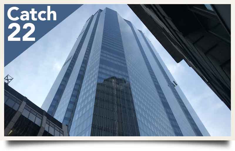 Towering glass exterior with caption 'Catch 22'.