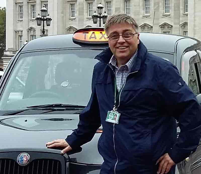 Standing by an iconic London Black Cab outside Buckingham Palace..