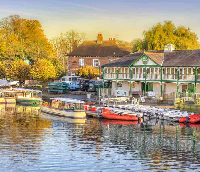 Boats moored up on the river Avon with pavilion of far bank.